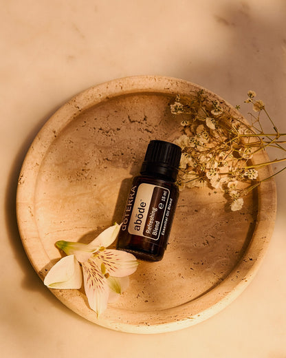 Abōde mélange d'huiles essentielles dōTERRA, flacon dans une coupelle en bois