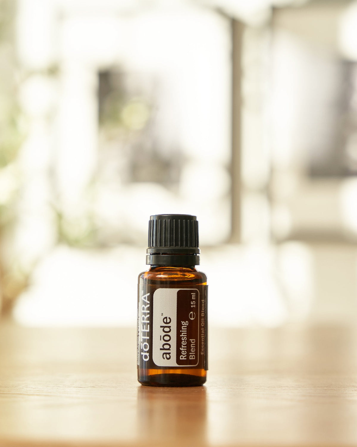 Abōde mélange d'huiles essentielles dōTERRA, flacon sur fond vert tendre