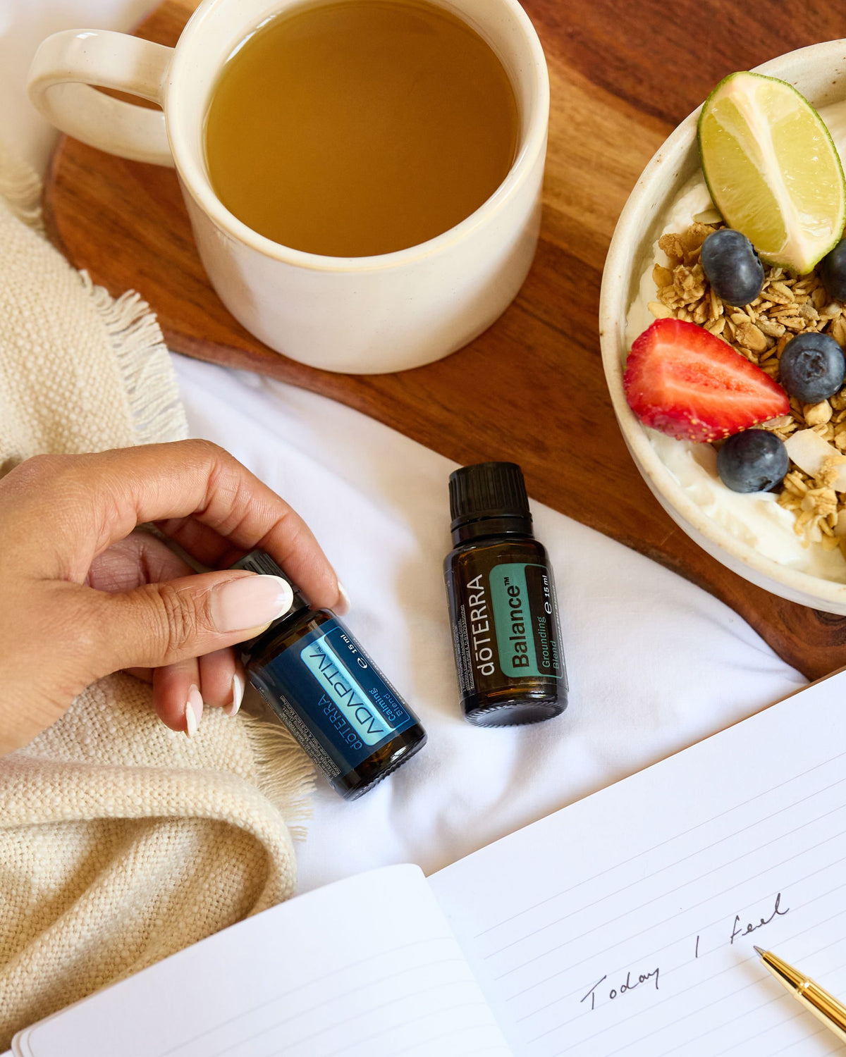 Adaptiv mélange d'huiles essentielles dōTERRA, flacon sur une table avec une tasse de thé