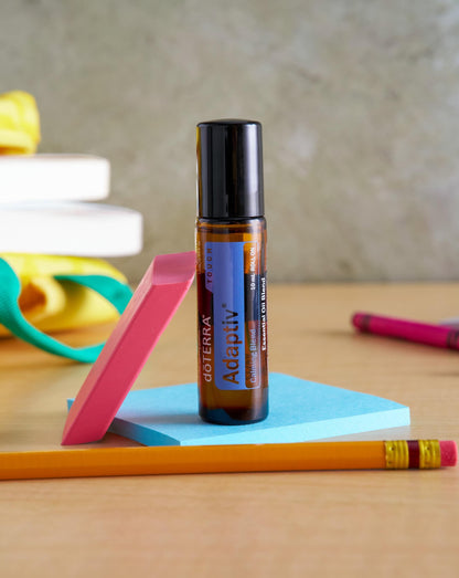 Adaptiv Touch mélange en applicateur à bille dōTERRA, roll-on sur un bureau avec des fournitures colorées