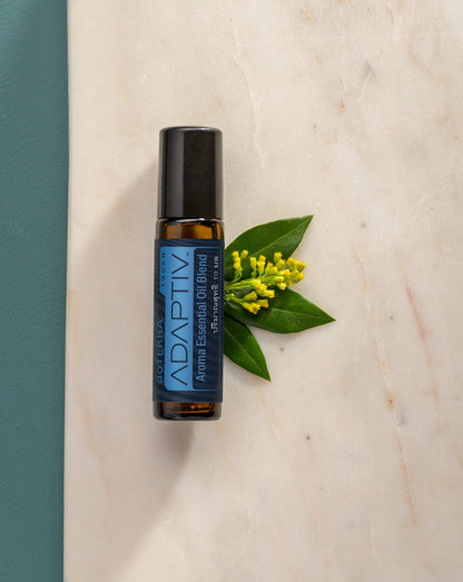 Adaptiv Touch mélange en applicateur à bille dōTERRA, roll-on sur du marbre avec des fleurs jaunes