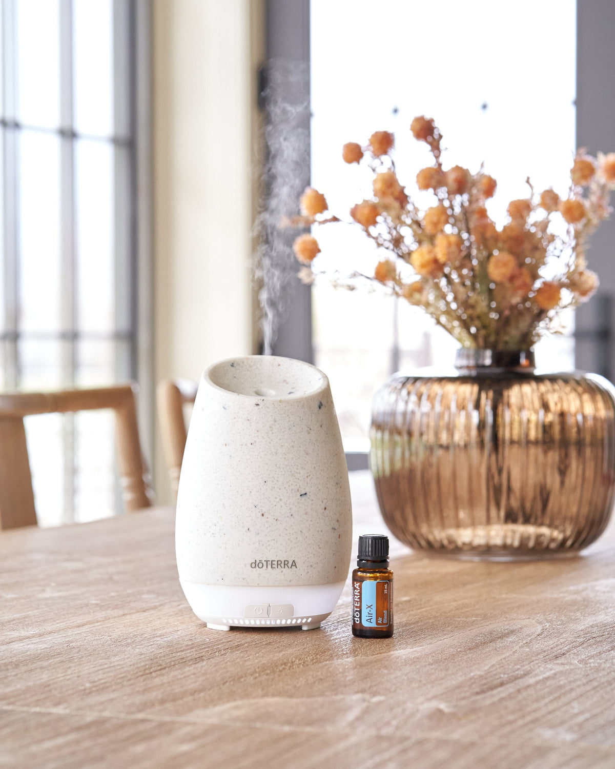 Air-X mélange d'huiles essentielles dōTERRA, flacon avec un diffuseur et des plantes