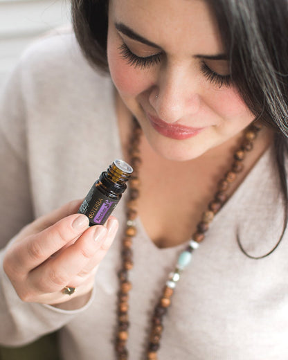 Anchor mélange d'huiles essentielles dōTERRA, flacon tenu par une femme