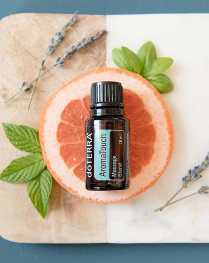 AromaTouch mélange d'huiles essentielles dōTERRA, flacon sur un pamplemousse avec de la lavande
