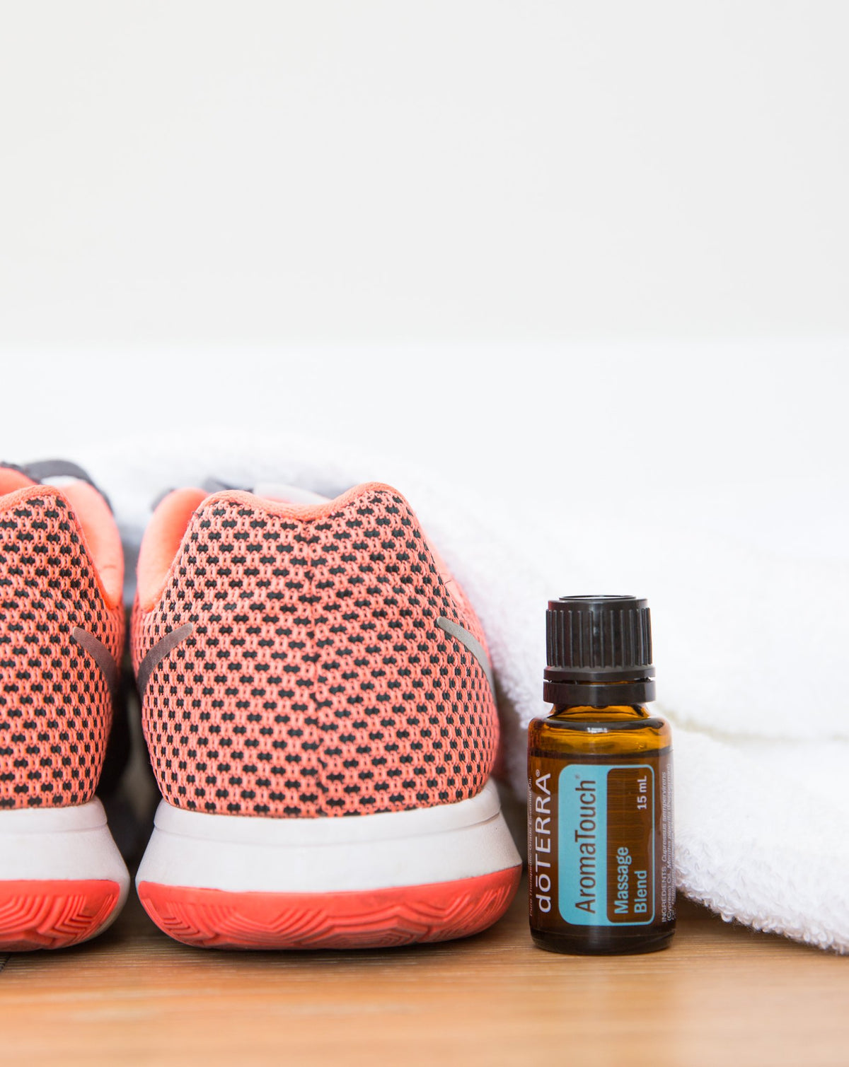 AromaTouch mélange d'huiles essentielles dōTERRA, flacon à côté de baskets et d'une serviette