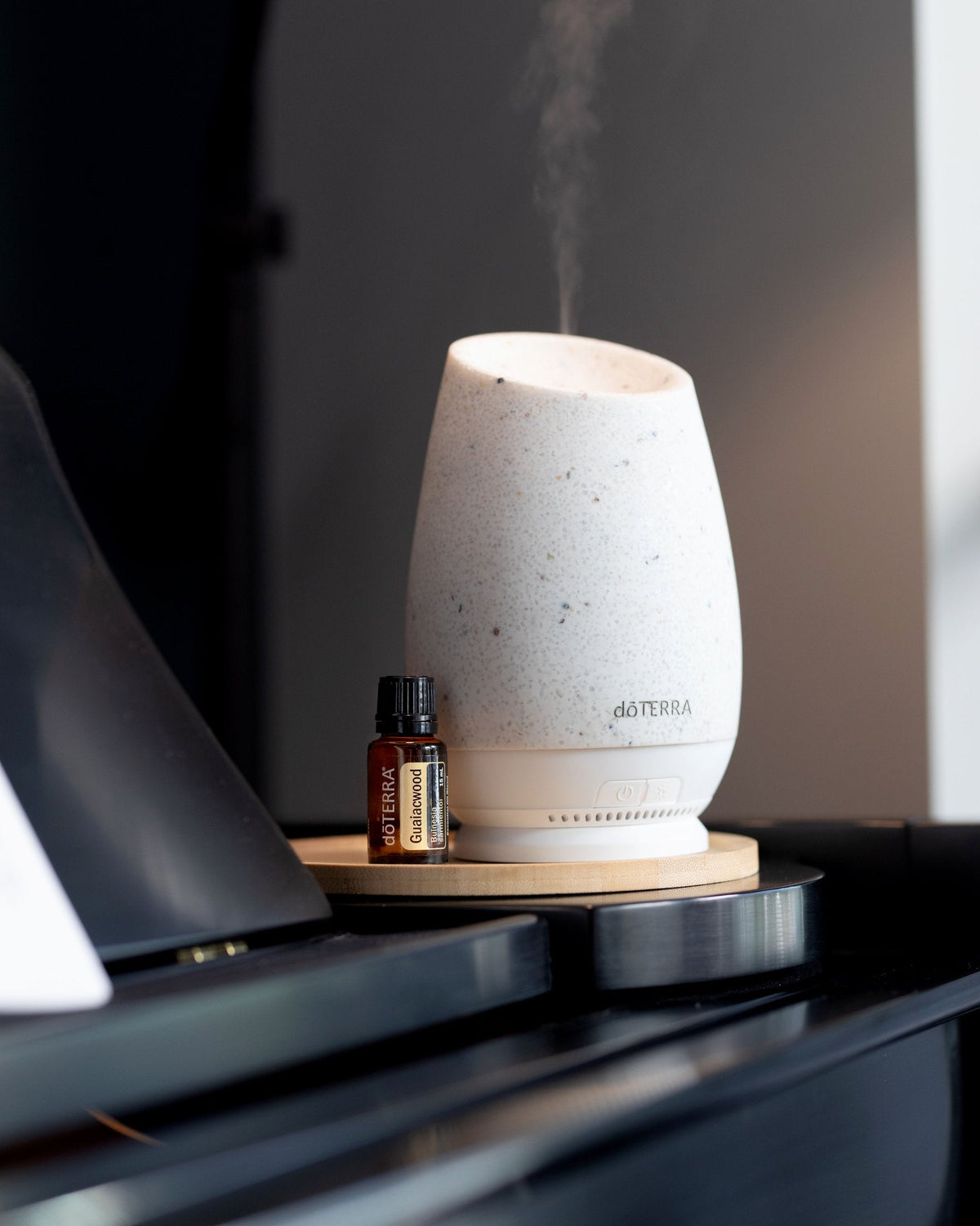 Bois de gaïac huile essentielle dōTERRA, à côté d'un diffuseur