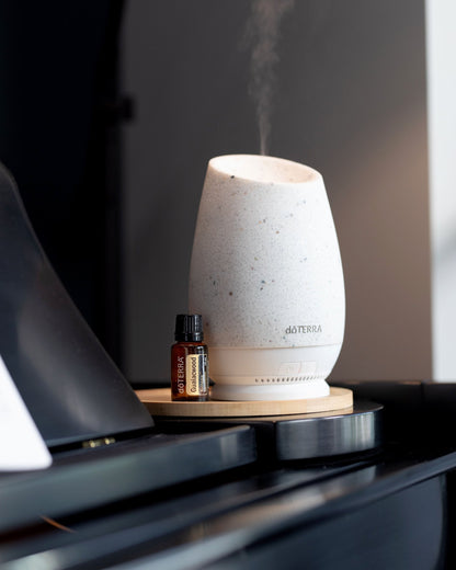 Bois de gaïac huile essentielle dōTERRA, à côté d'un diffuseur