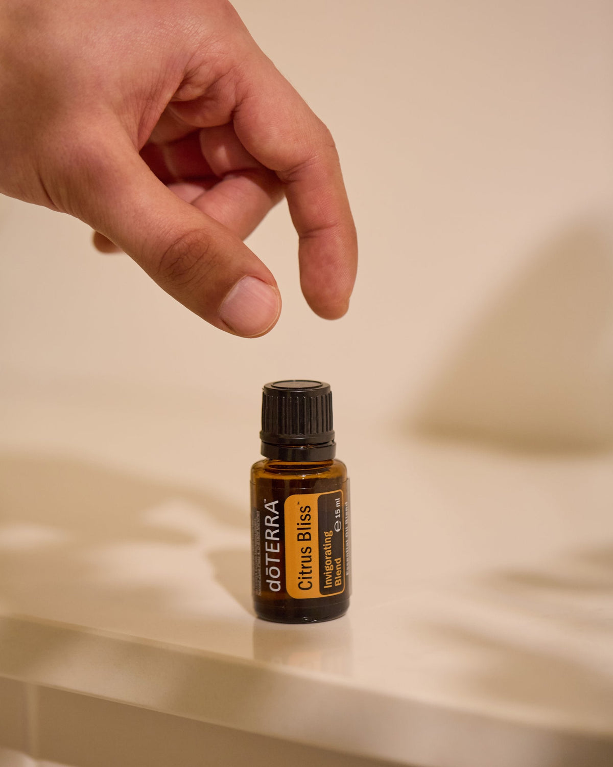Citrus Bliss mélange d'huiles essentielles dōTERRA, flacon tenu entre les doigts
