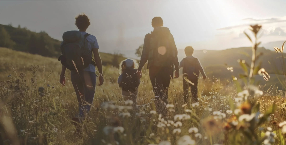 Une famille marche dans un champ fleuri au coucher du soleil