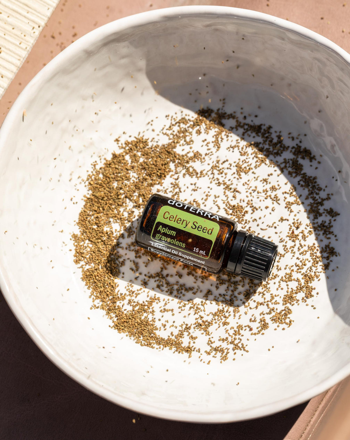 Graines de céleri huile essentielle dōTERRA, flacon sur des graines de céleri