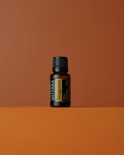 Mandarine huile essentielle dōTERRA, sur fond terracotta
