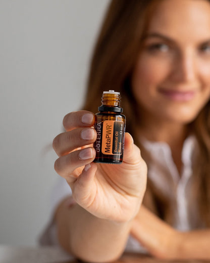 MetaPWR mélange d'huiles essentielles dōTERRA, flacon tenu par une femme