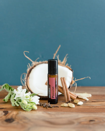 Passion mélange d'huiles essentielles dōTERRA, flacon avec fleurs séchées sur fond bleu-vert