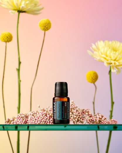 RevitaZen mélange d'huiles essentielles dōTERRA, flacon avec fleurs sur fond rose