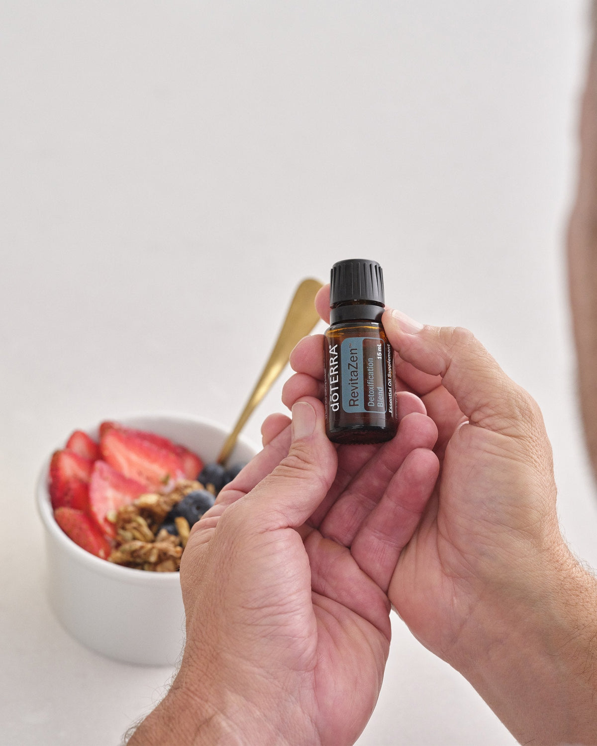 RevitaZen mélange d'huiles essentielles dōTERRA, flacon tenu en main
