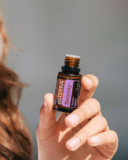 Serenity mélange d'huiles essentielles dōTERRA, flacon tenu en main